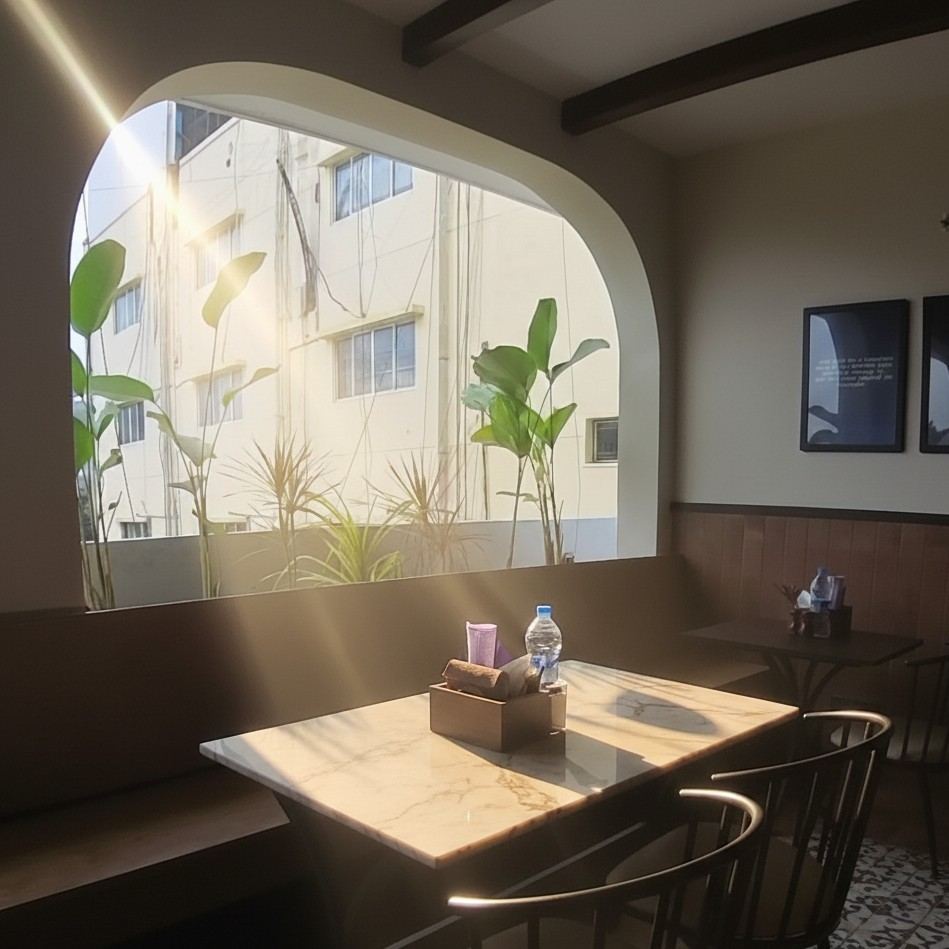 Morning light through the tall arched window at Cafe Here & Now