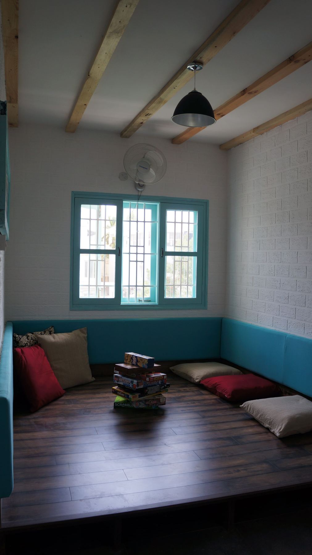 The skylit upper room with a low table and teal window frames