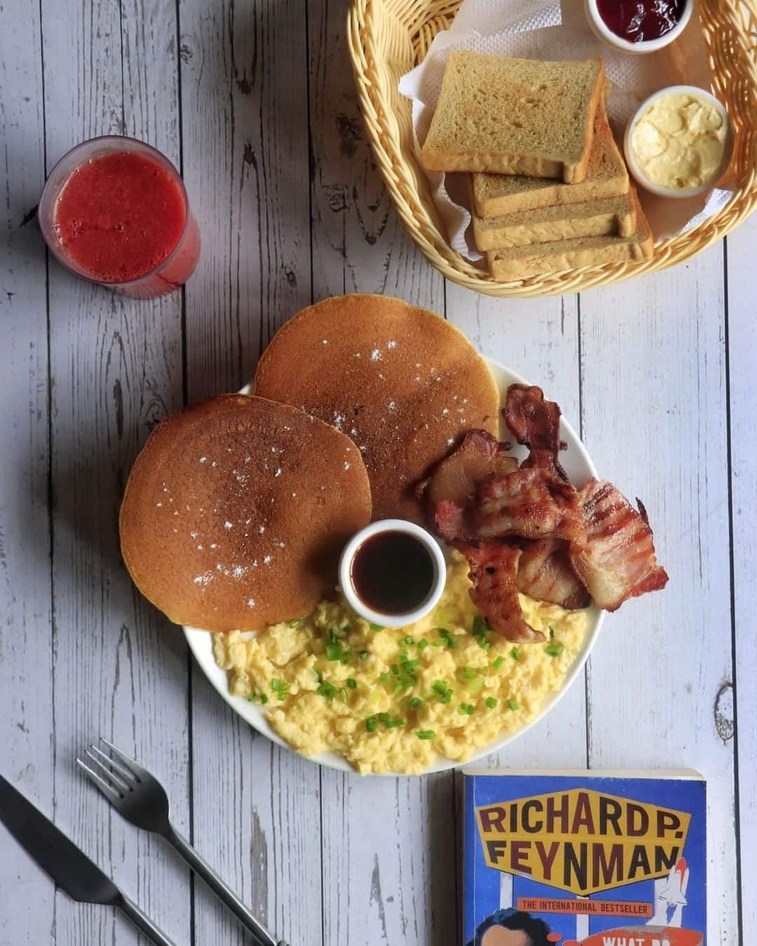 A burger and scrambled eggs photographed beside a Richard Feynman paperback