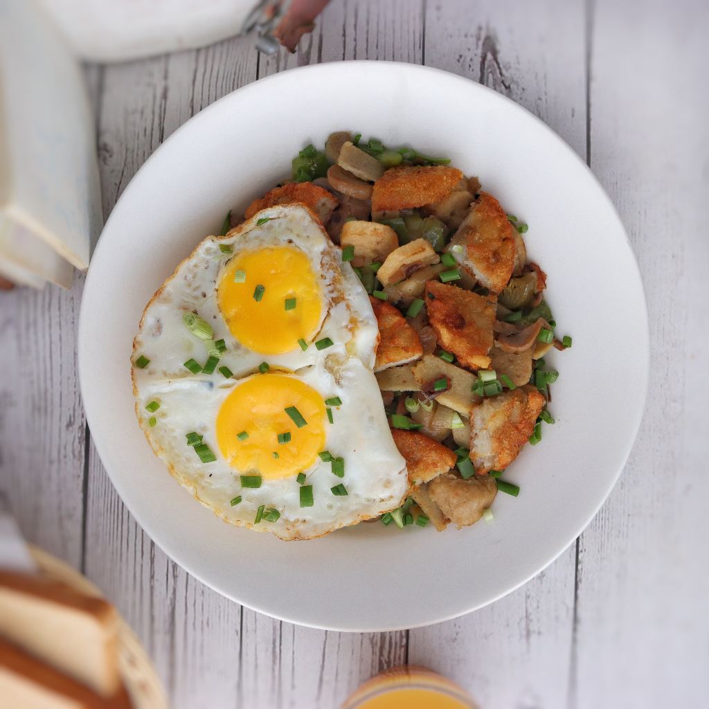 Two sunny-side-up eggs over sautéed potato and mushroom