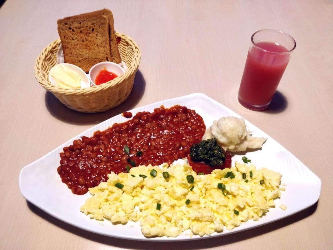 A breakfast spread with toast, beans and scrambled eggs